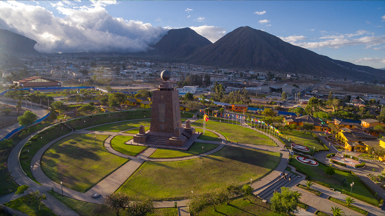 Monumento Mitad del Mundo con el fondo el Pululahua al atardecer